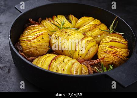 Modern style traditional potato chips with roasted onion rings and herbs served as top view in a design skillet Stock Photo