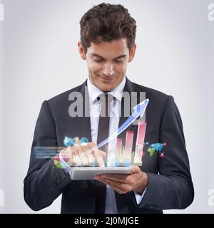 Your financial future is looking good. Studio shot of a young businessman analyzing data using his digital tablet. Stock Photo