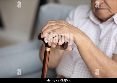 Close up cropped view disabled older man holds walking stick Stock Photo
