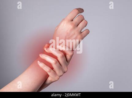 Woman hand holding painful wrist with red spot closeup. Health problems, injury, fatigue, overwork, office syndrome concept. High quality photo Stock Photo