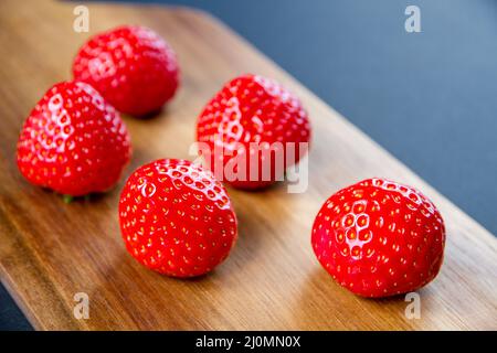 Strawberries on a cutting board. Black background Stock Photo