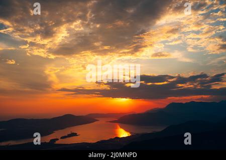 Orange clouds in the rays of the setting sun over the bay. View from Mount Lovcen Stock Photo