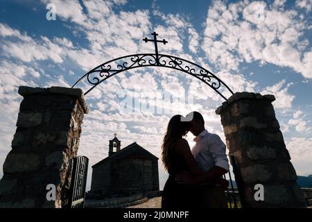 Kotor, Montenegro - 08.06.17: Newlyweds hug in front of the church gate of the Church of Sveti Savva on the mountain above Sveti Stock Photo