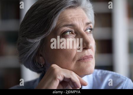 Close up face of thoughtful older businesswoman staring into distance Stock Photo