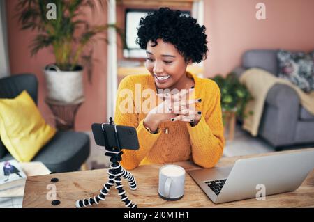 I cant wait to hear from you guys. Cropped shot of a woman recording a video for her blog at home. Stock Photo