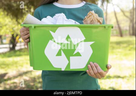 Close up woman holding recycling basket nature Stock Photo