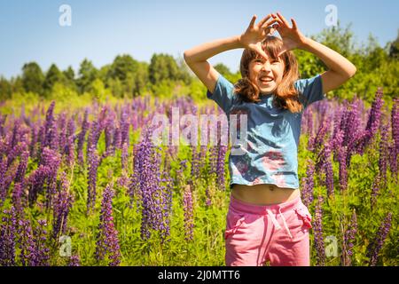 Little girl on the flower meadow. Happy childhood concept, child having fun. Stock Photo