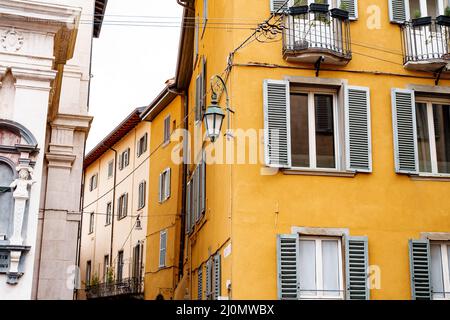 Metal lantern on the corner of an old house with shuttered windows. Bergamo, Italy Stock Photo