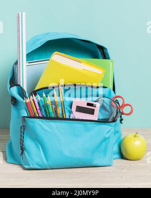 Blue school bag with essential supplies Stock Photo