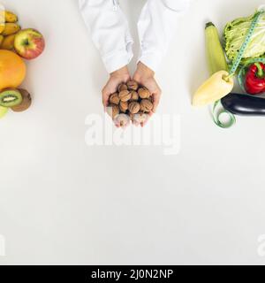 Close up person with vegetables holding nuts Stock Photo
