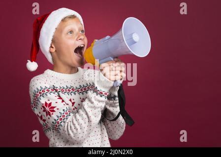 Christmas boy shouting through megaphone Stock Photo