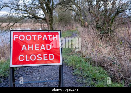 Red footpath ahead closed warning sign on a countryside trail Stock Photo