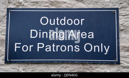 Blue Outdoor Dining Area for Patrons Only Wall Sign Stock Photo