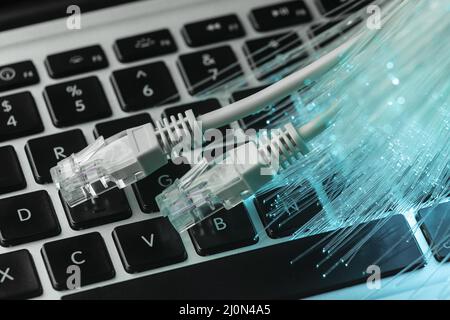 Blue optic fiber with ethernet cables laptop Stock Photo