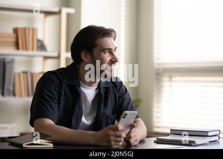 Positive happy business man in casual holding mobile phone Stock Photo