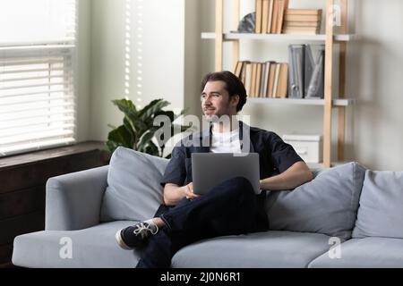 Dreamy pensive freelance man thinking over work project ideas Stock Photo