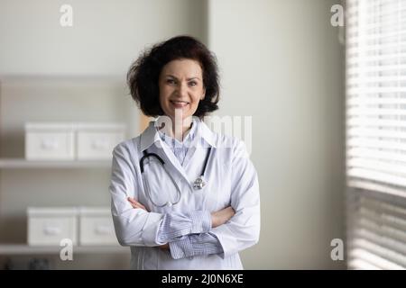 Confident happy mature chief doctor woman in white coat Stock Photo