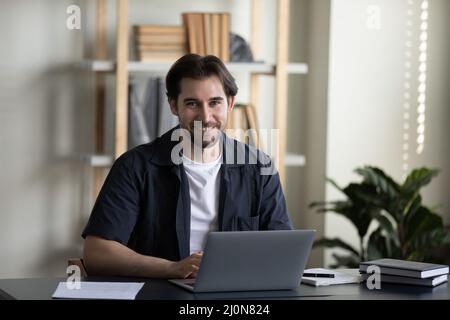 Happy business professional man in casual typing on laptop Stock Photo