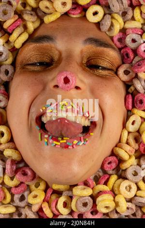 Vertical shot of a Caucasian woman's happy face surrounded by colorful sugary cereals, Spain Stock Photo