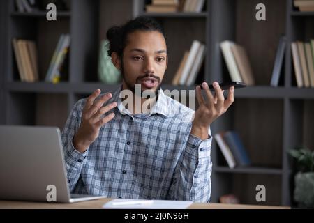 Serious Afro American freelancer man giving voice command Stock Photo