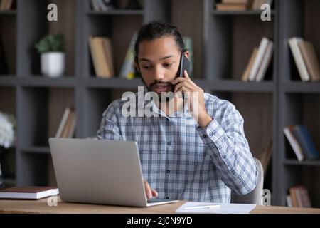 Serious busy African business professional guy working at laptop Stock Photo