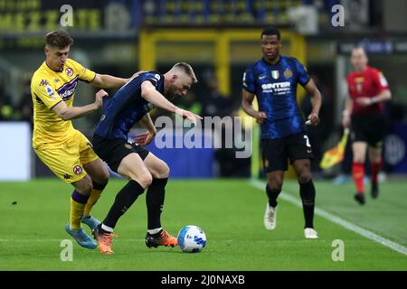 Milano, Italy. 19th Mar, 2022. Krzysztof Piatek of Afc Fiorentina and Milan Skriniar of Fc Internazionale battle for the ball during the Serie A match between Fc Internazionale and Acf Fiorentina at Stadio Giuseppe Meazza on March 19, 2022 in Milan, Italy. Credit: Marco Canoniero/Alamy Live News