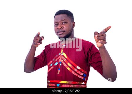 handsome young man pointing with two hands and fingers to the side and smiling at the camera Stock Photo
