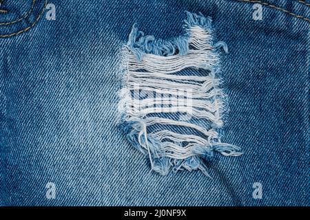 Hole and Threads on Denim Jeans Stock Photo