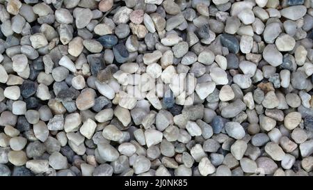 Background of large pile gray gravel stone pebbles, used in construction. Construction material concept. Selective focus. Top view. Close-up. Stock Photo