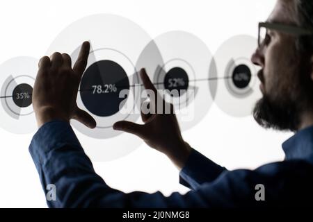 Close up of hand using creative business chart hologram settings on tech background Stock Photo