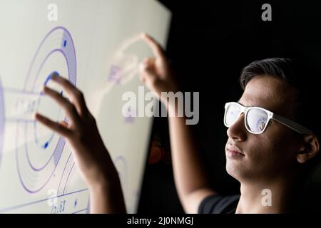 Close up of hand using creative business chart hologram settings on tech background Stock Photo