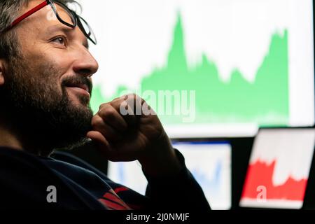 Crypto trader investor analyst looking at computer screen analyzing financial graph data on pc Stock Photo