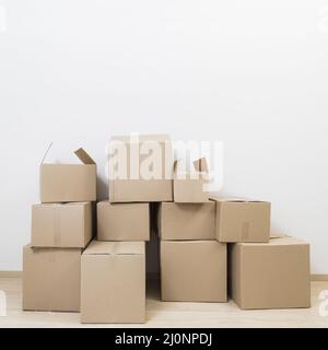 Stacked moving cardboard boxes against white wall. High quality and resolution beautiful photo concept Stock Photo