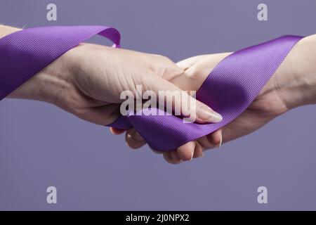 Women hands holding purple satin ribbon. High quality and resolution beautiful photo concept Stock Photo