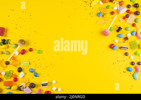 Various colorful candies lollipops yellow surface. High quality and resolution beautiful photo concept Stock Photo