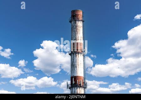 Large red white factory chimney against a cloudy summer sky Stock Photo