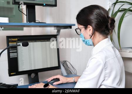 Asian woman doctor searching patient information from medical record system by using computer in hospital.. Stock Photo