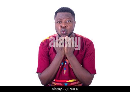 portrait of a handsome young man touching his beard and looking at the camera. Stock Photo