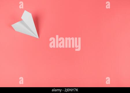 White paper airplane corner coral background. High quality and resolution beautiful photo concept Stock Photo