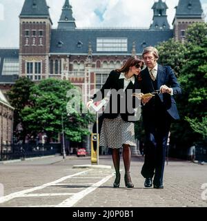 Vintage Amsterdam 1970s, stylish couple of middle aged tourists strolling in front of Rijksmuseum, Holland, Netherlands, Europe, Stock Photo