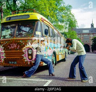 Vintage Amsterdam 1970s, couple taking funny pictures, hippy styled decorated bus, Holland, Netherlands, Europe, Stock Photo