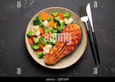 Grilled salmon steak with vegetables salad from above Stock Photo