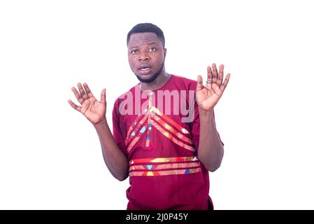 handsome young man wearing traditional shirt surprised and spreading hands. Stock Photo