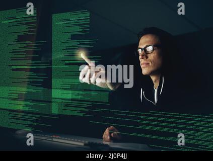 Hacking your system one touch at a time. Cropped shot of a young hacker cracking a computer code in the dark. Stock Photo