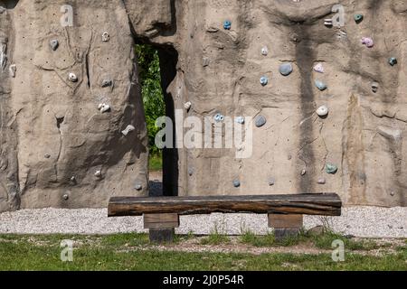 Climbing wall in urban park, manmade rock with holds and grips. Stock Photo