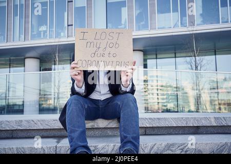 Job loss due to COVID-19 virus pandemic concept. Unrecognizable man holds sign I lost my job Stock Photo