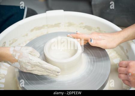 Close-up of woman's hands molding clay on wheel stock photo