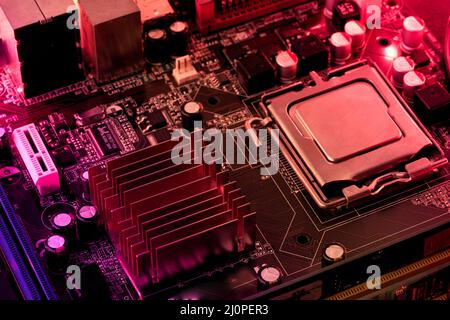 Computer motherboard background with blur neon multicolor glow, pc backdrop, close up Stock Photo
