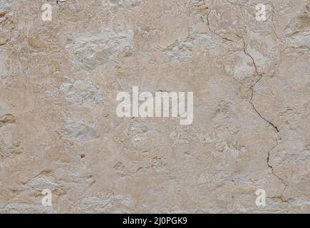 Beige stone wall with cracks. Stone background. Stock Photo