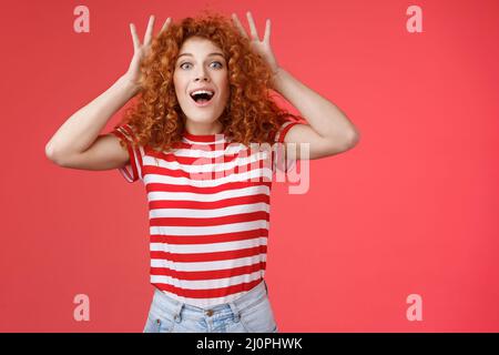 Impressed excited shocked young cute redhead curly-haired ginger girlfriend reacting amazed surprised awesome gift cannot believ Stock Photo